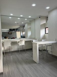 a room with chairs and a table and a kitchen at Hotel Dorado Ferial in Bogotá