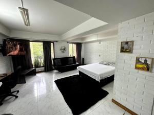 een slaapkamer met een bed en een bank in een kamer bij ApartaStudio El Poblado in Medellín