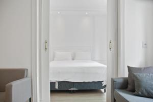 a bedroom with a white bed and a blue couch at Hotel Luxuoso na Paulista in Sao Paulo