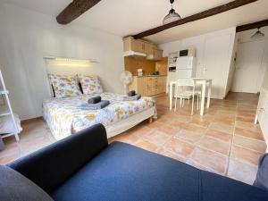 a living room with a bed and a kitchen at Virée à deux in Riez