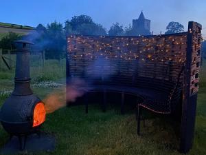 a fire grill with lights on it in a yard at Dôl Swynol Glamping Luxury cabin with outdoor bath in Aberystwyth