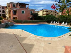 a large swimming pool in front of a building at Casa Ginevra in Santa Teresa Gallura