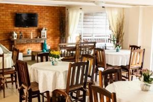 comedor con mesas y sillas y TV en Hotel Steinhausen Colonial, en Blumenau