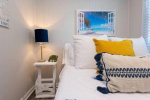 1 dormitorio con 1 cama y 1 mesa con lámpara en Family Beach Retreat w/Fun Loft Space, Firepit, en Michigan City
