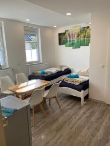 a room with two beds and a table and chairs at Haus Jörg in Lutter