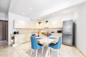 cocina con mesa, sillas y nevera en 4You Luxury Apartments by Keyplanner, en Moraitika