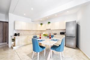 a kitchen with a table and chairs and a refrigerator at 4You Luxury Apartments by Keyplanner in Moraitika