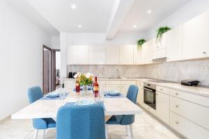 a kitchen with a table with blue chairs at 4You Luxury Apartments by Keyplanner in Moraitika