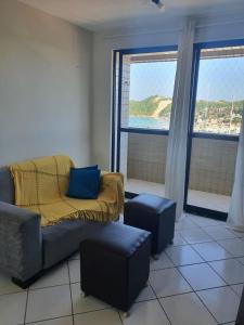 a living room with a couch and two windows at Apartamentos Natal in Natal