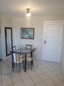 a dining room with a glass table and chairs at Apartamentos Natal in Natal
