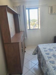 1 dormitorio con vestidor, cama y ventana en Apartamentos Natal, en Natal