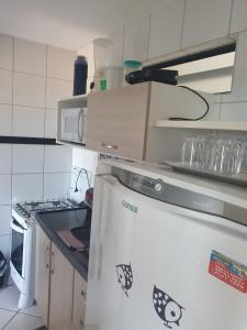 cocina con nevera blanca y microondas en Apartamentos Natal, en Natal