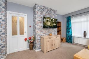 a living room with a brick wall and a door at Tibbersley House Billingham With Parking in Stockton-on-Tees