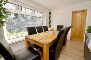 uma sala de jantar com uma mesa de madeira e cadeiras pretas em Dashing 4Bed Retreat - Walk to Stratford Town Centre & Shakespeare's Birthplace em Stratford-upon-Avon