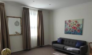 a living room with a couch and a window at The Hotel Shamrock in Bendigo