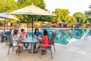 a group of women sitting at a table by a pool at MAJU HOTEL CAMPESTRE & SPA in Jamapa