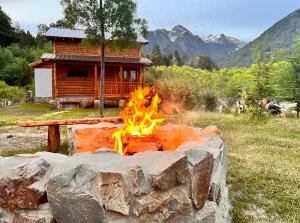 a fire pit in front of a log cabin at Rio Manso cabaña km 18 in Río Villegas