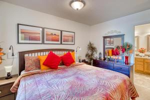 a bedroom with a large bed with colorful pillows at Rockaway Retreat - Meredith Lodging in Rockaway Beach