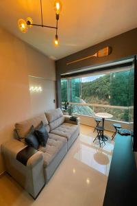 a living room with a couch and a large window at Studio de frente para o mar em Balneário Camboriú in Balneário Camboriú