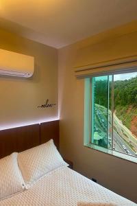 a bedroom with a bed and a window with a highway at Studio de frente para o mar em Balneário Camboriú in Balneário Camboriú