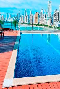 una gran piscina de agua con una ciudad al fondo en Studio de frente para o mar em Balneário Camboriú, en Balneário Camboriú