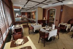 Un comedor con mesas y sillas en un restaurante. en Hôtel Au Petit Caporal, en Maisons-Alfort