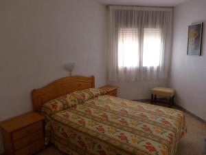 1 dormitorio con cama y ventana en CYE 5 Rentalmar, en La Pineda