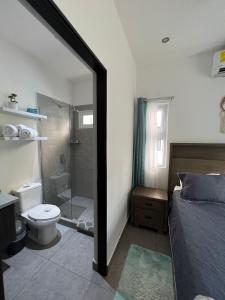 y baño con cama, ducha y aseo. en Lapa Lodge G1, en Jacó