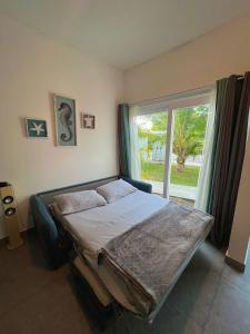 a bedroom with a bed and a large window at Lapa Lodge G1 in Jacó