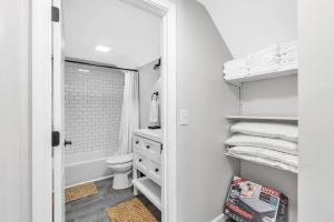 a white bathroom with a toilet and a sink at Pets, Big Groups Welcome: HotTub, Firepit, Grill in Bay City