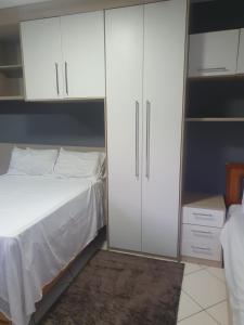 um quarto com uma cama e armários brancos em SUÍTE PRAIA DE ITAPARICA em Vila Velha