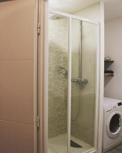 una doccia con porta in vetro in bagno di Votre bulle de confort a Servon