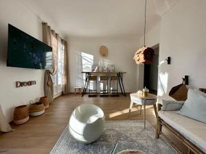 sala de estar con sofá blanco y mesa en Le LUTZ en Nimes