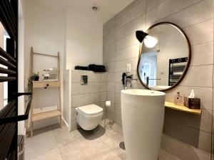 a bathroom with a toilet and a mirror at Le LUTZ in Nîmes