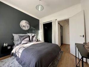 1 dormitorio con 1 cama grande y pared negra en Le LUTZ en Nimes