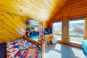 ein Schlafzimmer mit einem Bett und einem TV in einer Blockhütte in der Unterkunft Rio Vista Haven in South Fork