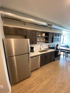 a kitchen with a stainless steel refrigerator and a sink at River Front Luxury Furnished Studio Downtown QC in Davenport
