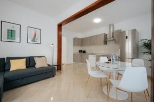 een woonkamer met een bank en een tafel en stoelen bij 4 Esquinas Adeje Homes in Adeje