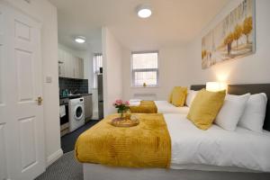 a bedroom with two beds and a kitchen at Swan Studio Two - Coventry in Coventry