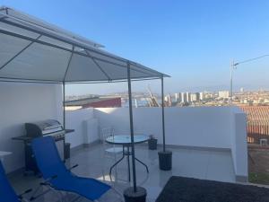 a balcony with a table and chairs and an umbrella at La Casa Blanca Departamento 1 in Coquimbo