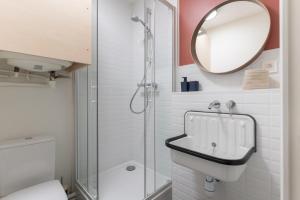 een badkamer met een douche, een wastafel en een spiegel bij Studio refait à neuf avec Parking en Bord de Loire in Nantes