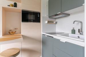 een witte keuken met een wastafel en een aanrecht bij Studio refait à neuf avec Parking en Bord de Loire in Nantes