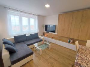 ein Wohnzimmer mit einem Sofa und einem TV in der Unterkunft Apartmán Pod zámkem in Mikulov