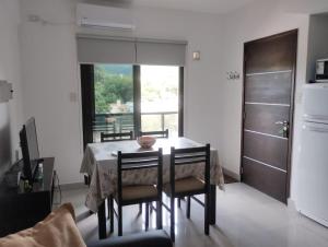 a dining room with a table and chairs and a refrigerator at Departamento XIBI in San Salvador de Jujuy