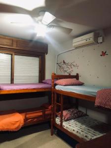a room with two bunk beds and a window at Apto Bonfim Redenção 2 carros e sacada vip in Porto Alegre