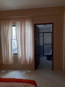 a bedroom with a door to a room with a window at Cómo en hogar in Tarija