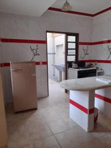 uma cozinha com uma mesa, um frigorífico e um balcão em Cómo en hogar em Tarija