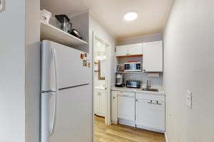 大洋城的住宿－Ocean Waye 226，厨房配有白色橱柜和冰箱。