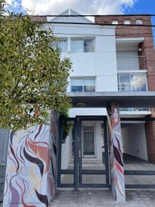 un edificio con una puerta con una pintura. en Departamento Céntrico con Cochera - 2 Ambientes - Tandil en Tandil