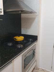 uma panela amarela sentada em cima de um fogão numa cozinha em Apartamento Caruaru em Caruaru
